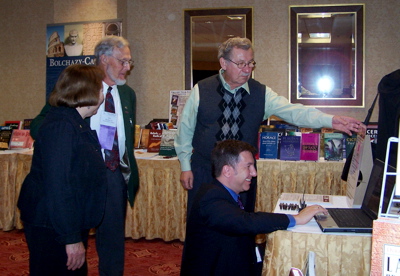 Adults gather beside a table displaying books.