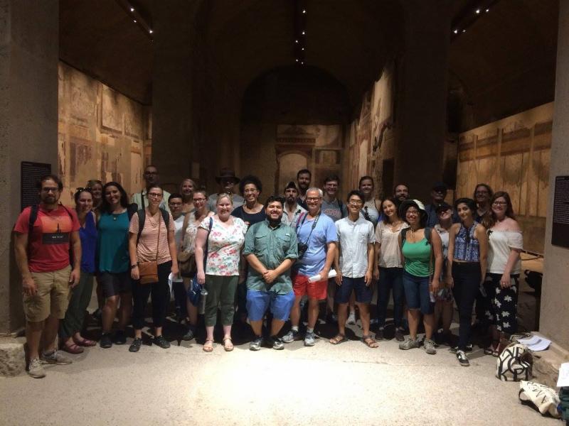 A group of adults poses together inside a museum gallery.
