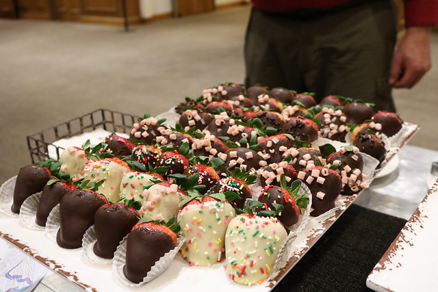 A tray of decorated sweets is displayed on a table.